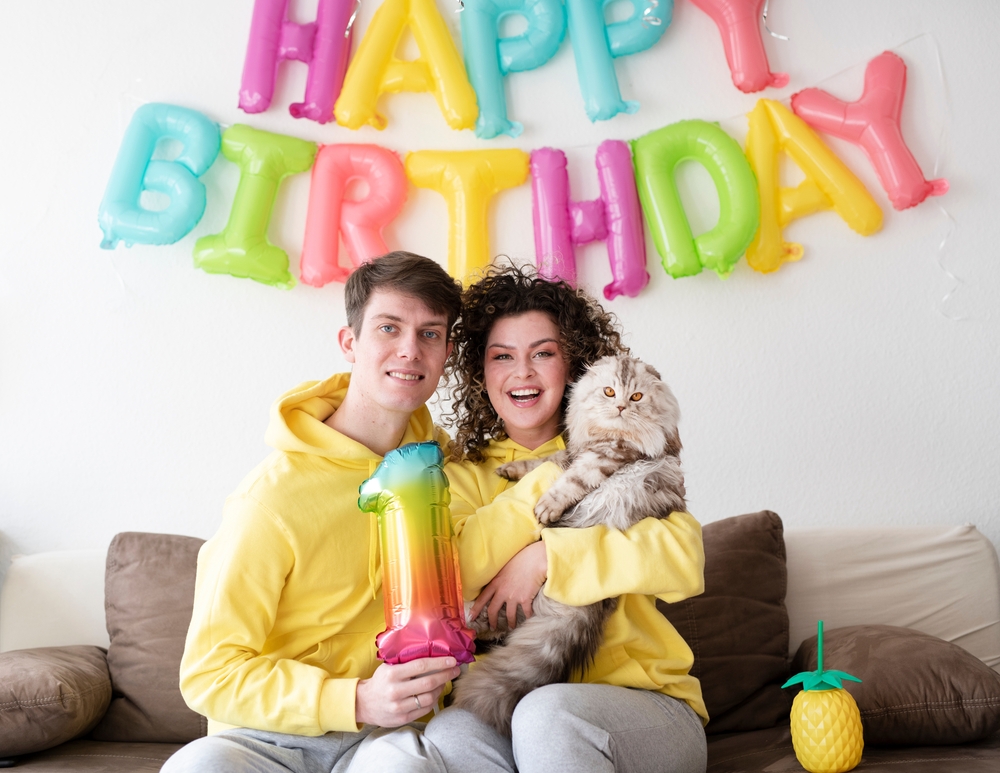Happy family celebrating a birthday with their cat, showing the bond between pets and families